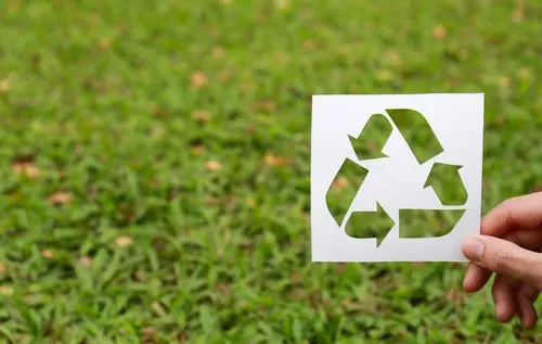 Logo de reciclaje sobre fondo de césped